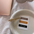 Detailed macro view of a gold-plated long rectangular hair clip with a fine grain texture - Gold Label Barrette / Clear White