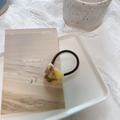 Close-up of elegant acetate hair tie with marble texture on ceramic tray background - Buttercream