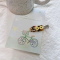 Detailed shot of daisy acetate hair clip with tortoiseshell texture and metal beak clip - Yellow Sunflower - Clear Tortoiseshell
