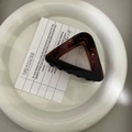 Detailed top view of a dark amber triangle hair claw clip with glossy finish on white tray - 8.5cm / Dark Tortoiseshell
