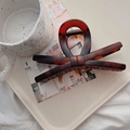 Detailed view of an amber tortoiseshell bow hair claw clip on a minimalist tray - 13.5cm / Matte Tortoise (X Bow)