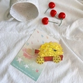 Detailed close-up of a creative fruit cart hair claw clip on soft white fabric - Durian Cart