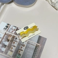 Detailed view of yellow and cream wavy acetate hair clips on a premium display card - Bright Yellow + Cream White