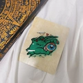 Detail der grünen Zombie-Hand-Haarklammer mit roten Nägeln und blauem Augapfel-Design - Böse Hand Augapfel Klammer