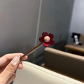 Détail d'une barrette fleur en acétate rouge foncé avec perle centrale et clip argenté - Grande Fleur Pince en Acétate / Rouge Kaki