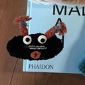 Zwarte pluizige monster haarclip met oranje hoorns en grote ogen op een boek - Zwart