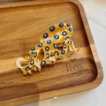 Dettaglio molletta per capelli a polpo giallo con motivi blu su vassoio in legno - Polpo Dagli Anelli Blu