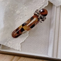 Elegante haarklem met schildpateffect, luipaardprint strik en zilveren metalen embleem - Koffie Schildpad Strik