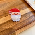 Dettaglio ravvicinato della molletta per capelli Babbo Natale in acetato su vassoio - Babbo Natale