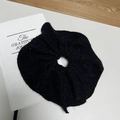 Elegant black knit mink fur scrunchie hair tie placed on a white journal desk setting - Black