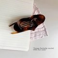 Detail of dark brown tortoiseshell hair claw clip with vintage hollowed butterfly design - Bright French