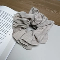 Elegante elastico per capelli a righe beige e marrone su un libro aperto - Scacchi Bianco Nero