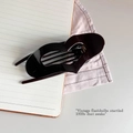Close-up of a minimalist black heart-shaped hair claw clip on a stylish desk background - Brown Camel