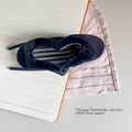 Detail of dark translucent heart hair claw clip on a notebook and striped fabric background - Ultramarine Blue