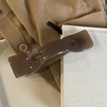 Detail einer dunkelbraunen Haarklammer in Schleifenform auf weichem Strickhintergrund - Transparent Braun