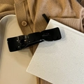 Detail of elegant black ribbon hair claw clip placed on a tray for a French aesthetic - Coffee