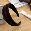 Detail of dark brown flocked headband with triple row thick design on wooden surface - Coffee