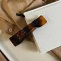 Nahaufnahme einer Haarklammer mit Schildpatt-Muster und bernsteinfarbener Textur - Helles Französisch
