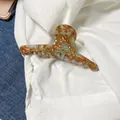 Detail of amber marble hair claw with Barrette La France gold stamp on denim background - Coffee Green - Large (Approx 12.5cm)