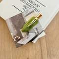 Detail of French acetate hair clip in olive green with gold logo on aesthetic background - Emerald Stripe