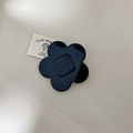 Molletta per capelli a fiore nero lucido con incisione wer wer su sfondo beige - Rosa Nera Piccola