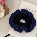 Close-up of knit scrunchie featuring contrast dark blue and black wool texture - Blue-Black