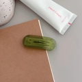 Frosted green rectangular hair clip with white lettering on a notebook background - Transparent Emerald Green