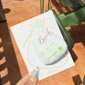 White fabric hair tie with green apple print and pink ribbon on a display card - Pink Bow Rabbit Apple Clip