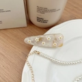Dettaglio di un fermaglio per capelli a fiore e collana di perle su un vassoio bianco - Clip Laterale Fiore Strass a Goccia / Primavera Rosa Giallo