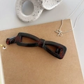 Detail of dark brown tortoiseshell banana hair clip in elegant hollow bow-knot design - Shiny Tortoiseshell