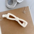Elegant cream white bow-shaped banana hair clip made of premium resin on paper background - Solid White