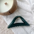 Detail of a large 12cm dark green hollow triangle hair claw clip on soft white fabric - Peacock Green