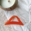 Macro shot of large orange geometric hair claw clip with marble texture and gold spring - Jelly Orange