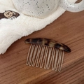Detailansicht Haarkamm aus Schildpatt-Acetat mit goldenem Logo und silbernen Metallzinken - Schwarzgoldener Glitzer