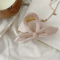 Gros plan détaillé d'une pince à cheveux papillon nude avec ressort doré brillant - Rose Nude Clair