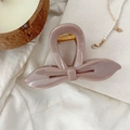 Détail d'une pince à cheveux papillon en résine rose poudré sur un fond en tissu esthétique - Rose Nude Foncé
