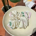 Cream satin scrunchie featuring green apple embroidery and a pink ribbon bow detail - Pink Bow Letter Apple Scrunchie