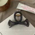 Détail de la pince à cheveux en résine grise montrant la texture et le ressort doré - 8.5cm / Gris foncé