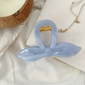 Détail d'une pince à cheveux nœud bleu clair avec ressort doré sur tissu texturé - Bleu Ciel