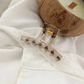 Close-up of leopard print hair claw clip with gold spring on white lace fabric - 5.2cm / Transparent Brown Leopard
