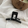 Detail of a sleek black 5cm hair claw clip on white lace with a scented candle decoration - 5.2cm / Bright Black
