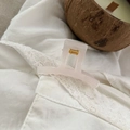 Close-up of translucent pale pink square hair claw clip with golden spring on lace fabric - 5.2cm / Jelly White