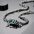 Dettaglio macro del ciondolo con gemma verde smeraldo e collana gotica a doppia catena - Collana Serpente Verde