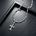 Gothic cross necklace in silver finish with pavé set crystals on a black wood display - Necklace