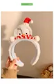 Dettaglio del cerchietto in peluche a forma di pinguino blu con cappello natalizio - Stile Pinguino Blu