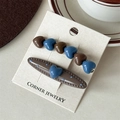 Detail of heart hair clips set in brown and blue resin on white display card - Blue Coffee Contrast Heart Style
