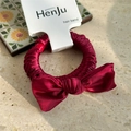 Close-up of a deep red satin bow hair tie with elegant silk texture on a marble surface - Ruched Satin with Card / New Year Red