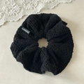 Close-up of black lace crochet scrunchie with a white Handmade woven label detail - Black