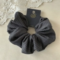 Detail view of a grey striped fabric scrunchie on a handmade branded display card - Grey Stripe