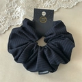 Detail of grey striped fabric scrunchie with handmade label on a lace background - Navy Stripe